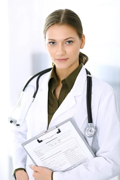 Doctora de pie recta y mirando a la cámara. Servicio médico perfecto en la clínica. Futuro feliz en medicina y salud — Foto de Stock