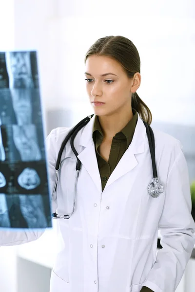 在医院检查X光照片的女医生。在诊所工作的外科医生或矫形师。医药和保健概念 — 图库照片