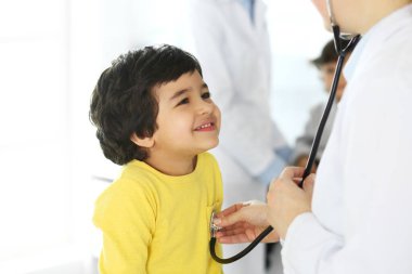 Doktor steteskopla çocuk bir hastayı muayene ediyor. Doktor randevusunda tatlı bir Arap çocuk. Tıp ve sağlık hizmetleri kavramı