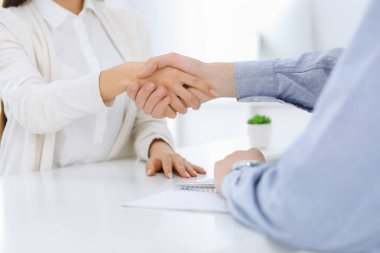 İş adamları toplantıda ya da pazarlıkta el sıkışıyor. İş adamı ve kadın ofiste masada otururken tokalaşıyorlar. Başarı konsepti