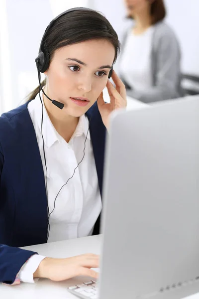 Centro de atendimento. Mulher bonita recepcionista sentado no fone de ouvido no escritório de atendimento ao cliente. Grupo de operadores a trabalhar. Conceito de negócio — Fotografia de Stock