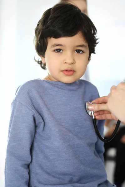 Az orvos sztetoszkóppal vizsgál meg egy gyermekbeteget. Aranyos arab fiú az orvosnál. Orvosi és egészségügyi koncepció — Stock Fotó
