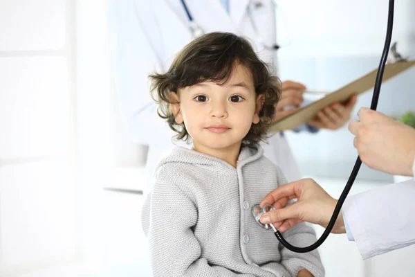 Médico examinando uma criança paciente por estetoscópio. Rapaz árabe bonito na consulta médica. Conceito de medicina e saúde — Fotografia de Stock