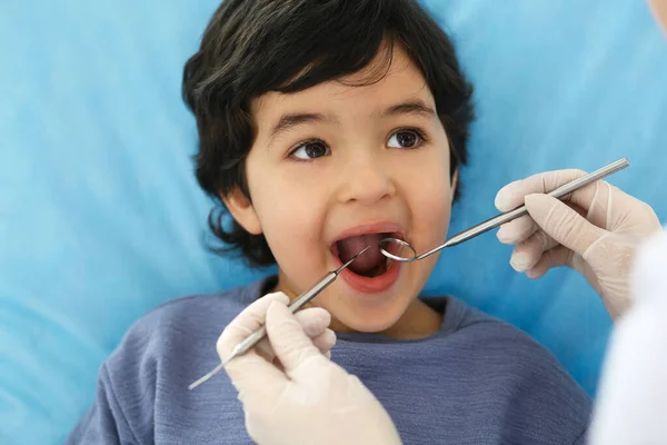 Little arab boy sitting at dental chair with open mouth during oral check up while doctor. Visiting dentist office. Medicine and stomatology concept — Stock Photo, Image