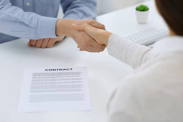 Geschäftsleute beim Händeschütteln bei Treffen oder Verhandlungen nach Vertragsgesprächen. Geschäftsmann und Frau Händedruck im Büro, während sie am Schreibtisch sitzen. Erfolgskonzept — Stockfoto