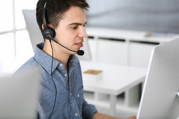 Grupo de operadores en el trabajo. Centro de llamadas. Concéntrate en la recepcionista joven en auriculares al servicio al cliente. Concepto de negocio y estilo de ropa casual —  Fotos de Stock