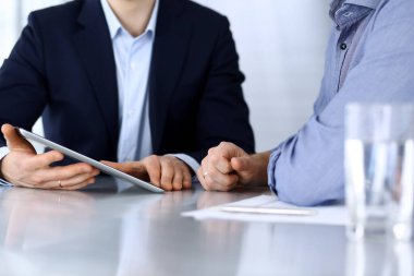 Modern ofiste birlikte çalışırken iş adamları tablet bilgisayar kullanıyorlar. İş yerinde iş arkadaşı olan tanınmamış bir iş adamı ya da erkek girişimci. Takım çalışması ve ortaklık kavramı