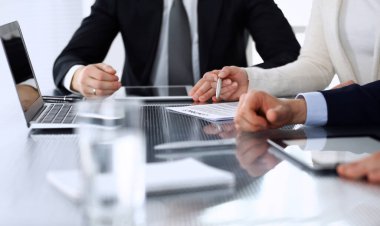 İş adamları modern ofisteki cam masasında birlikte çalışarak sözleşmeyi tartışıyor. İş arkadaşları ya da avukatları olan tanınmamış bir iş adamı ve kadın. Takım çalışması ve ortaklık