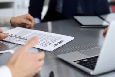 İş adamları modern ofisteki cam masasında birlikte çalışarak sözleşmeyi tartışıyor. İş arkadaşları ya da avukatları olan tanınmamış bir iş adamı ve kadın. Takım çalışması ve ortaklık