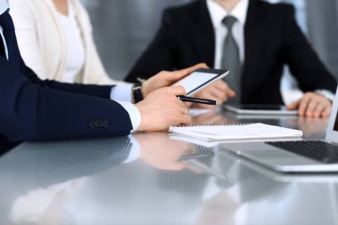 İş adamları modern ofisteki cam masasında birlikte çalışarak sözleşmeyi tartışıyor. İş arkadaşları ya da avukatları olan tanınmamış bir iş adamı ve kadın. Takım çalışması ve ortaklık