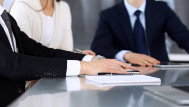 İş adamları modern ofisteki cam masasında birlikte çalışarak sözleşmeyi tartışıyor. İş arkadaşları ya da avukatları olan tanınmamış bir iş adamı ve kadın. Takım çalışması ve ortaklık