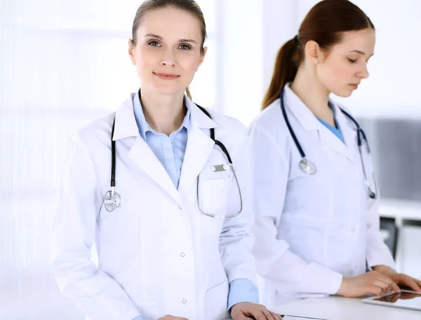 Grupo de médicos en el trabajo en el hospital. Médico llenando documentos médicos o receta mientras está de pie en la recepción. Datos en medicina y concepto de salud — Foto de Stock