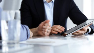 Modern ofiste birlikte çalışırken iş adamları tablet bilgisayar kullanıyorlar. İş yerinde iş arkadaşı olan tanınmamış bir iş adamı ya da erkek girişimci. Takım çalışması ve ortaklık kavramı