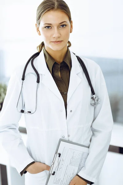Mujer-médico de pie y mirando a la cámara. Medicina y asistencia sanitaria — Foto de Stock