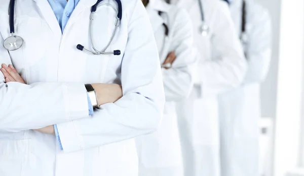 Een groep moderne dokters staat als een team met gekruiste armen in het ziekenhuiskantoor. Medische hulp, verzekering in de gezondheidszorg, beste desease behandeling en geneeskunde concept — Stockfoto