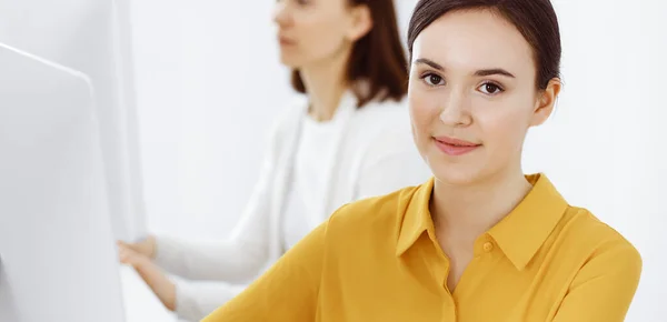 Mujer de negocios en blusa de color mostaza mirando a la cámara en la oficina, foto en la cabeza —  Fotos de Stock