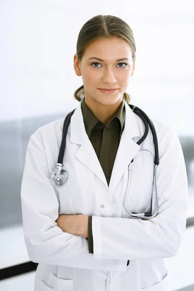 女医生交叉着胳膊站在那里，看着镜头。完美的医疗服务在诊所。医药和保健 — 图库照片