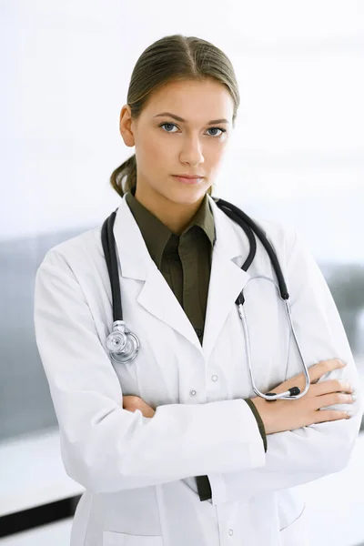 Mujer-médico de pie con los brazos cruzados y mirando a la cámara. Servicio médico perfecto en la clínica. Medicina y asistencia sanitaria — Foto de Stock