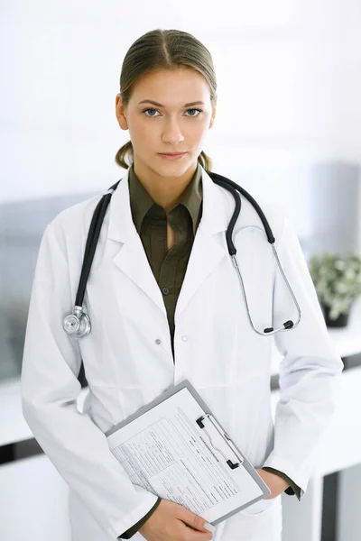 Mujer-médico de pie y mirando a la cámara. Servicio médico perfecto en la clínica. Medicina y asistencia sanitaria — Foto de Stock