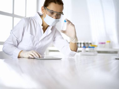 Kadın laboratuvar asistanı hastanede kan örneğini inceliyor. Tıp, sağlık ve araştırma konsepti