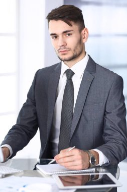 Modern ofiste bilgisayarla çalışan bir iş adamı. Arap erkek girişimcinin ya da iş yerindeki müdürün vesikalığı. İş konsepti