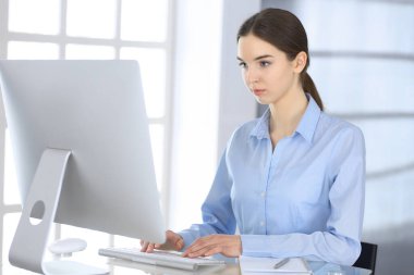 Modern ofisteki cam masada bilgisayarla çalışan bir iş kadını. Sunum hazırlayan öğrenci kız ya da dengeyi sağlayan muhasebeci. Vergi ve denetim kavramı