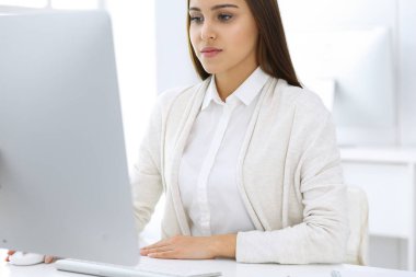 Beyaz ofisteki bilgisayarla çalışan bir iş kadını. Öğrenci kız ders çalışıyor ya da sekreter rapor yazıyor. Başarı konsepti