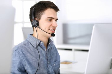 Bir grup operatör iş başında. Merkezi ara. Müşteri hizmetlerindeki genç resepsiyoniste odaklan. İş konsepti ve günlük giyim tarzı