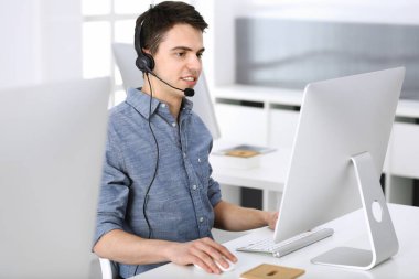 Bir grup operatör iş başında. Merkezi ara. Müşteri hizmetlerindeki genç resepsiyoniste odaklan. İş konsepti ve günlük giyim tarzı