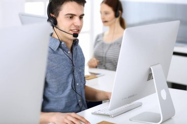 Bir grup operatör iş başında. Merkezi ara. Müşteri hizmetlerindeki genç resepsiyoniste odaklan. İş konsepti ve günlük giyim tarzı