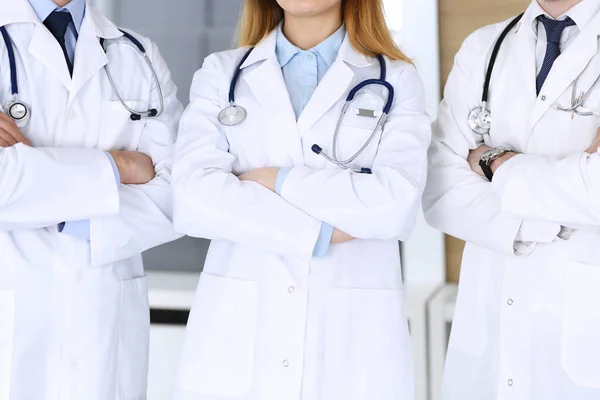 Grupo de médicos modernos em pé como uma equipe com os braços cruzados no escritório do hospital, close-up. Médicos prontos para examinar e ajudar os pacientes. Ajuda médica, seguro de saúde, melhor tratamento e — Fotografia de Stock