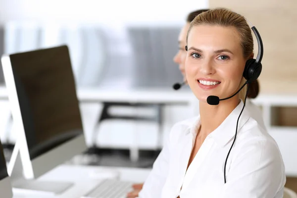 呼叫中心快乐而兴奋的女商人在网上咨询客户时使用耳机。客户服务办公室或电话营销部门.在工作中微笑的一组操作员 — 图库照片