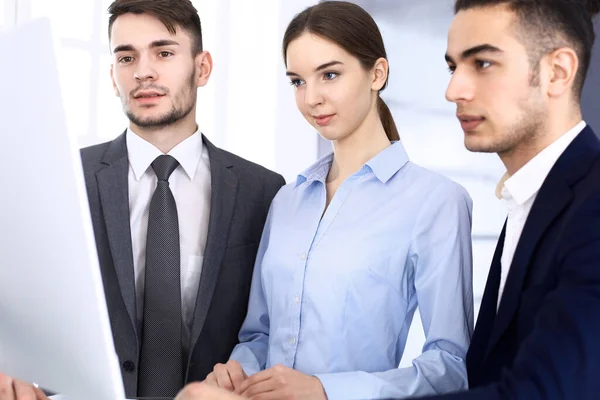 Groep van diverse zakenmensen bespreken vragen bij een ontmoeting in het moderne kantoor. Collega 's die op de werkplek met computers werken. Multi-etnische teamwork en business concept — Stockfoto