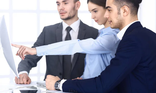 Grupo de empresarios diversos discutiendo preguntas en la reunión en la oficina moderna. Colegas que trabajan con computadoras en el lugar de trabajo. Trabajo en equipo multiétnico y concepto de negocio — Foto de Stock