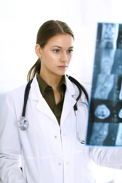 La dottoressa sta esaminando una foto a raggi X in ospedale. Chirurgo o ortopedico al lavoro in clinica. Medicina e concetto di assistenza sanitaria — Foto Stock