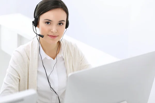 Centro de atendimento. Mulher bonita recepcionista sentado no fone de ouvido no escritório de atendimento ao cliente. Grupo de operadores a trabalhar. Conceito de negócio — Fotografia de Stock