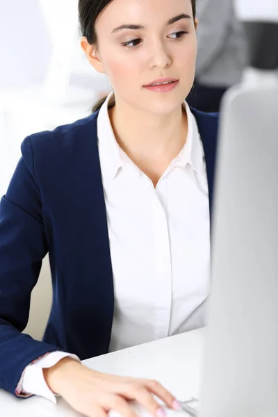 Mujer de negocios que trabaja con la computadora en la oficina, colega de fondo. Imagen de Abogado o Contador en el trabajo mientras está sentado en el escritorio —  Fotos de Stock