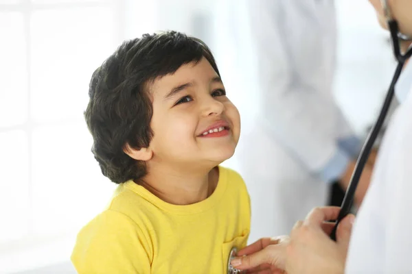 Läkare undersöker en barnpatient med stetoskop. Söt arabpojke på läkarbesök. Medicin och hälsovård — Stockfoto