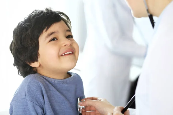 Médico examinando a un niño paciente por estetoscopio. Lindo chico árabe en la cita con el médico. Concepto de medicina y salud — Foto de Stock
