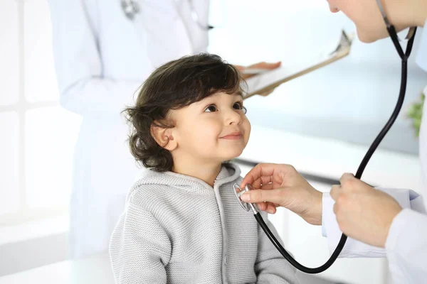 Médico examinando uma criança paciente por estetoscópio. Rapaz árabe bonito na consulta médica. Conceito de medicina e saúde — Fotografia de Stock