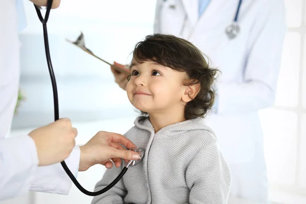 Médico examinando uma criança paciente por estetoscópio. Rapaz árabe bonito na consulta médica. Conceito de medicina e saúde — Fotografia de Stock