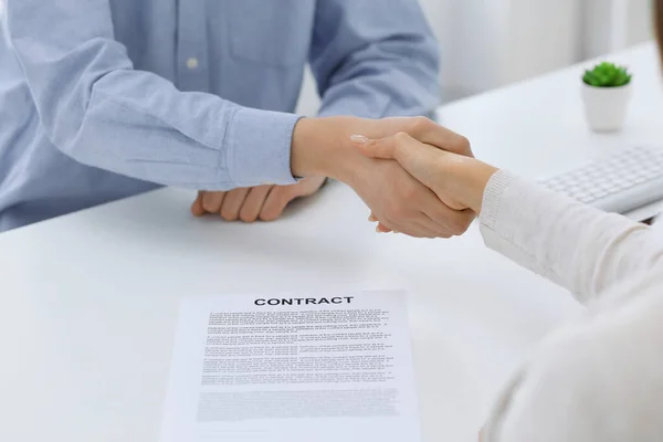 Business people shaking hands at meeting or negotiation after contract discussing. Businessman and woman handshake at office while sitting at the desk. Success concept — Stock Photo, Image