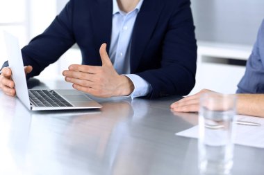 Modern ofiste birlikte çalışırken dizüstü bilgisayarı kullanan iş adamları. İş yerinde iş arkadaşı olan tanınmamış bir iş adamı ya da erkek girişimci. Takım çalışması ve ortaklık kavramı