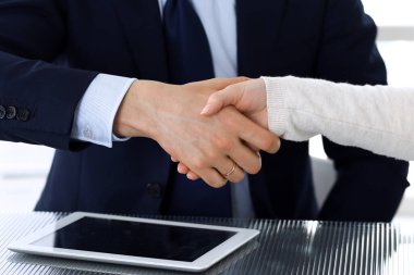 Modern ofisteki cam masasında iş adamları kontrattan sonra el sıkışıyor. Meçhul iş adamı, iş arkadaşları ile toplantıda ya da pazarlıkta olan erkek girişimci. Takım çalışması, ortaklık ve