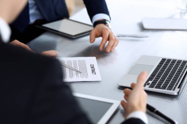 İş adamları modern ofisteki cam masasında birlikte çalışarak sözleşmeyi tartışıyor. İş arkadaşları ya da avukatları olan tanınmamış bir iş adamı ve kadın. Takım çalışması ve ortaklık