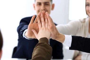 Takım çalışması yapan ve el ele tutuşan iş adamları grubu ya da modern ofiste kontrat imzaladıktan sonra beş kişi. Meslektaşları ya da avukatları olan tanınmamış işadamı ve kadın elleriyle daire çiziyor.