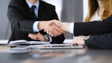 İş adamı, modern ofiste iş arkadaşı veya ortağıyla el sıkışıyor. Yakın plan. Toplantıda bilinmeyen iş adamları var. Takım çalışması, ortaklık ve el sıkışma kavramı