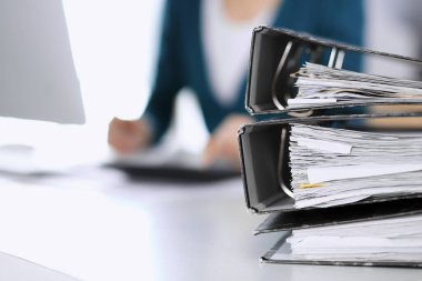 Belgeleri olan dosyalar, iş kadını ya da ofisteki büroda çalışan muhasebeci tarafından incelenmeyi bekliyor. Denetim ve vergi kavramı