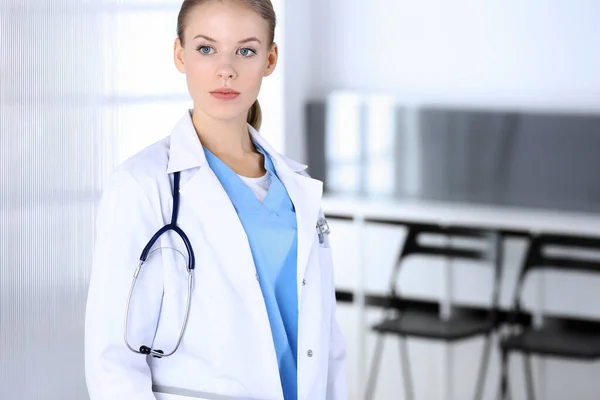Женщина-врач, стоящая в отделении скорой помощи. Врач за работой, студийный портрет. Концепция медицины и здравоохранения — стоковое фото