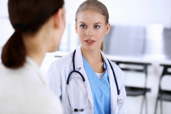 Doctor y paciente durante la consulta. Médico en el trabajo llenando el historial de medicamentos mientras está sentado en el hospital de emergencia, sesión de fotos. Concepto de medicina y salud — Foto de Stock